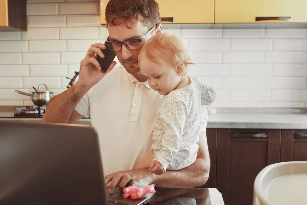 Családi apa dolgozik egy laptop az interneten keresztül, beszél phon - Fotó, kép