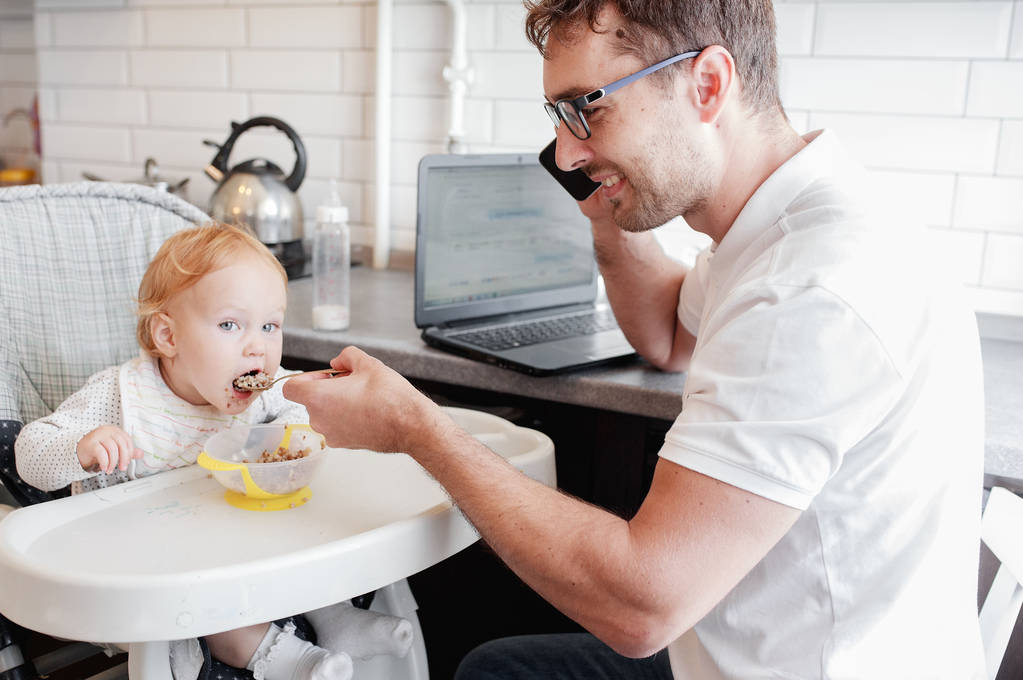 Mutlu genç baba evde çalışan ve bir kız bebek ile oturan. - Fotoğraf, Görsel
