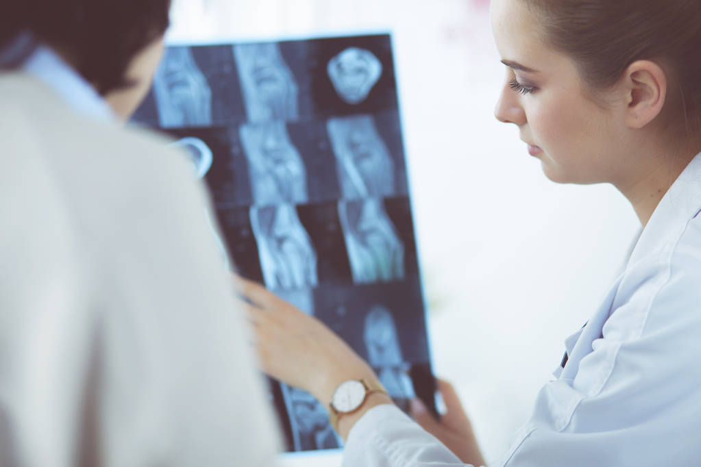 Młodzi lekarze badający zdjęcia rentgenowskie w klinice - Zdjęcie, obraz