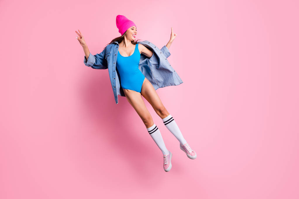 Koko kehon kuva funky nuori tekee v-merkkejä yllään sininen vartalo puku valkoinen polvi-sukat eristetty vaaleanpunainen tausta
 - Valokuva, kuva
