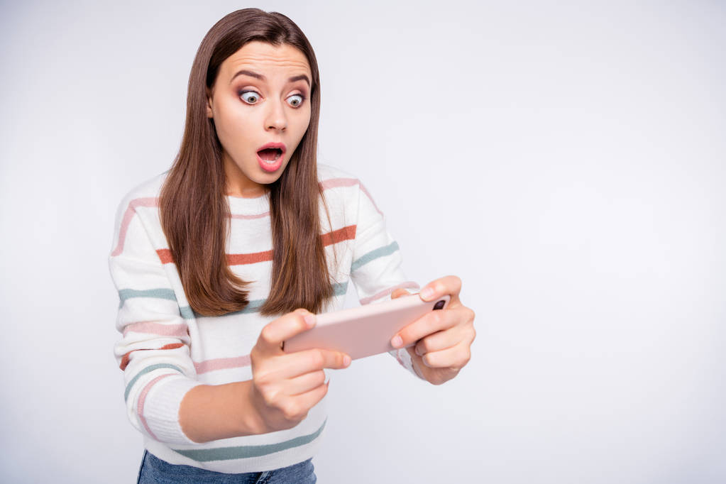 Podekscytowany Lady przerażony utraty telefonu Android gra nosić pasiasty sweter na białym tle - Zdjęcie, obraz