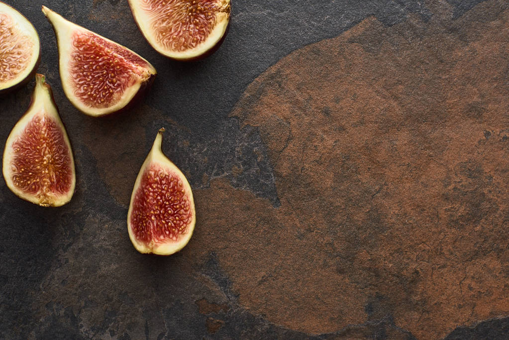 top view of ripe cut delicious figs on stone background with copy space - Photo, Image