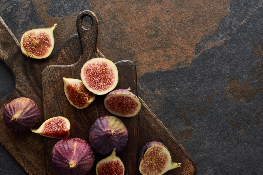 top view of ripe whole and cut delicious figs and cutting boards on stone background - Photo, Image
