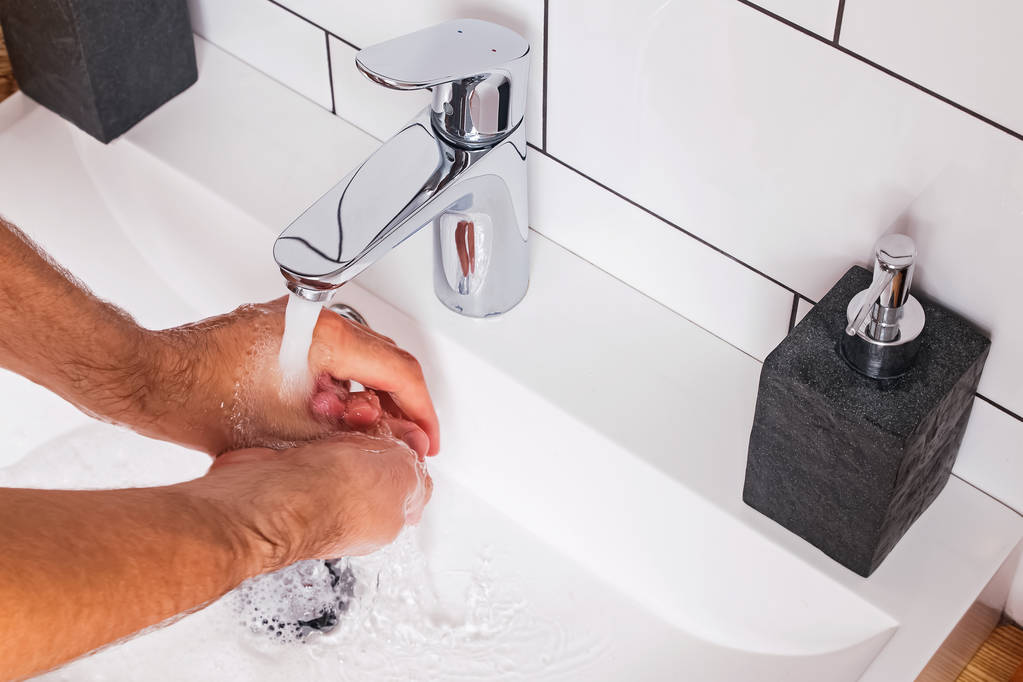 Homem lavando as mãos no banheiro moderno
. - Foto, Imagem