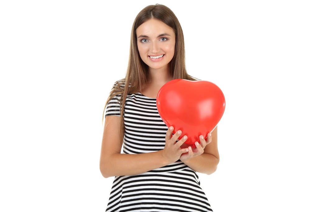 Νεαρή γυναίκα κρατώντας μπαλόνι σε σχήμα καρδιάς σε λευκό πίσω - Φωτογραφία, εικόνα
