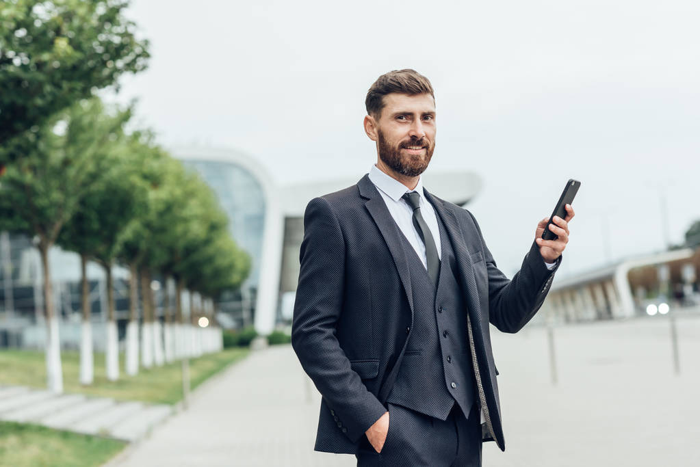 Handsome man in suit using smartphone - Photo, Image