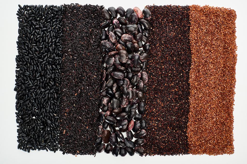 pohled na rozmanité černé fazole, rýže, quinoa a pohanka izolované na bílém - Fotografie, Obrázek
