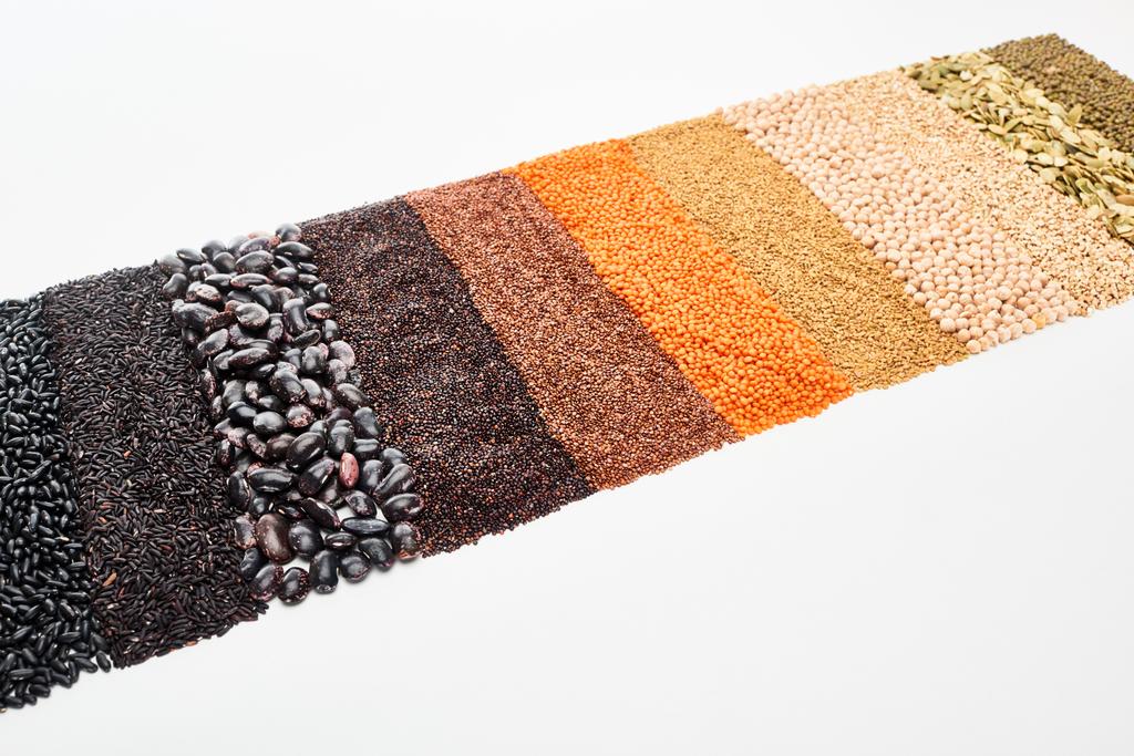 černé fazole, rýže, quinoa, cizohrachová semena, pohanka, maash a červená čočka izolovaná na bílém - Fotografie, Obrázek