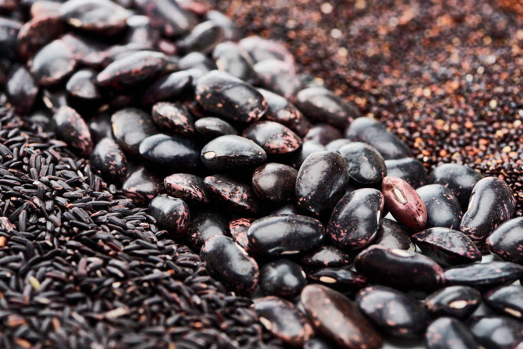 Close-up van zwarte bonen tussen quinoa en rijst - Foto, afbeelding