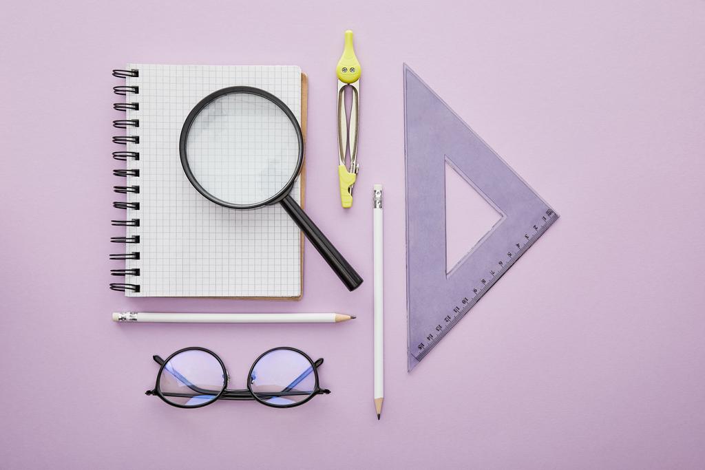 vista superior del triángulo de reglas cerca de lupa en el cuaderno cerca de lápices, brújula de dibujo y gafas aisladas en púrpura
  - Foto, Imagen