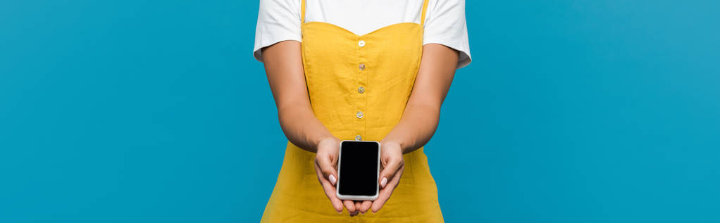 foto panorámica de la mujer sosteniendo teléfono inteligente con pantalla en blanco aislado en azul
  - Foto, Imagen