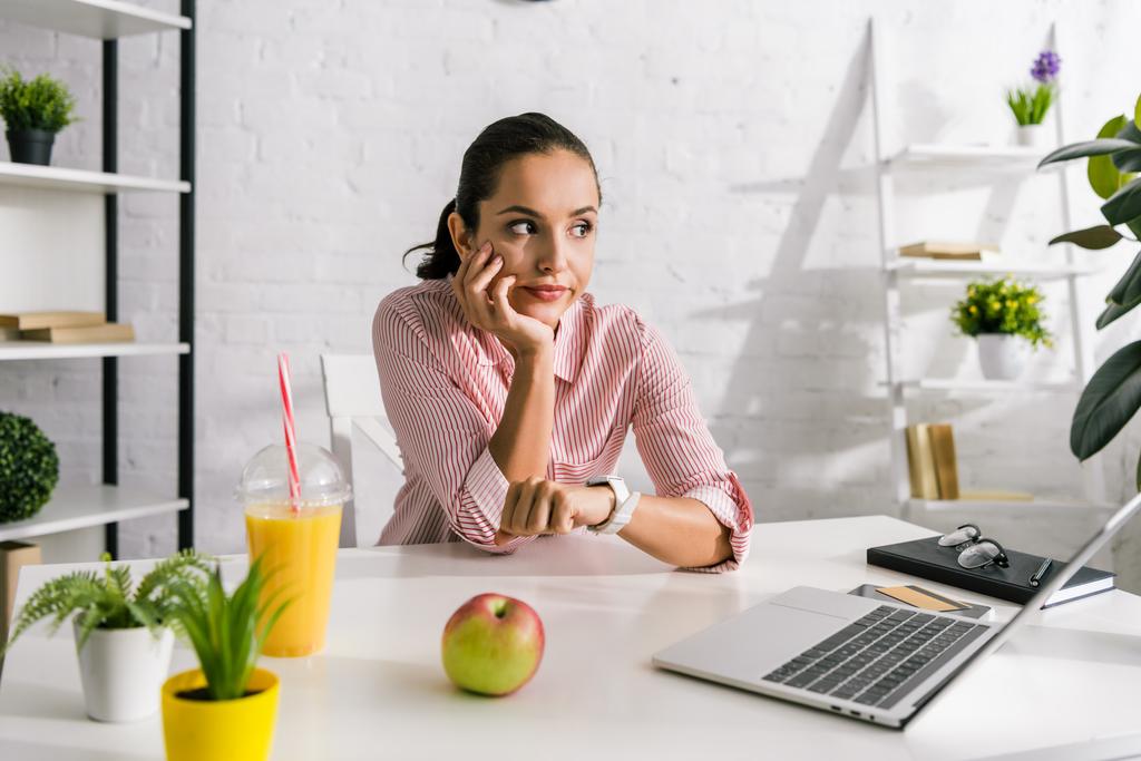 недовольная девушка рядом ноутбук и яблоко в офисе
  - Фото, изображение