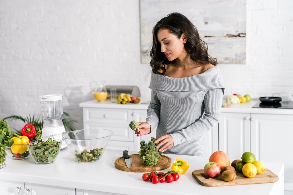 junge attraktive Frau bereitet zu Hause Salat zu  - Foto, Bild