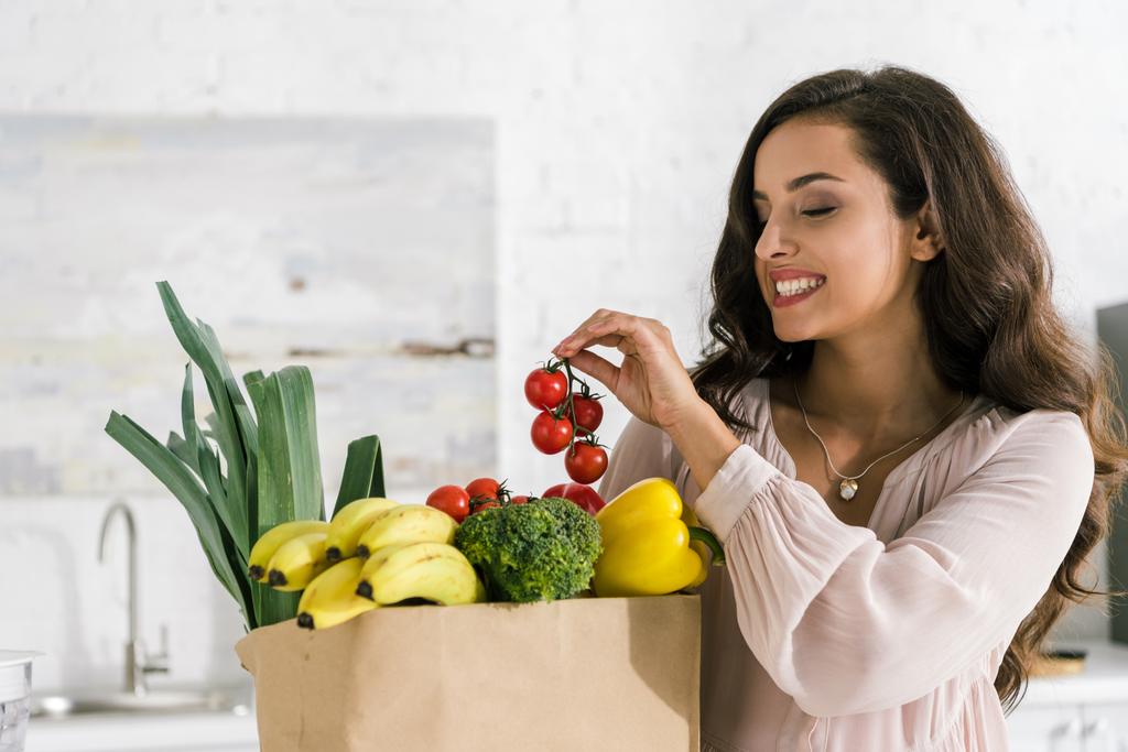 happy young woman holding red cherry tomatoes  - Photo, Image