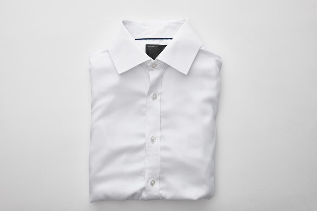 επάνω όψη του απλού διπλωμένο πουκάμισο σε λευκό φόντο - Φωτογραφία, εικόνα
