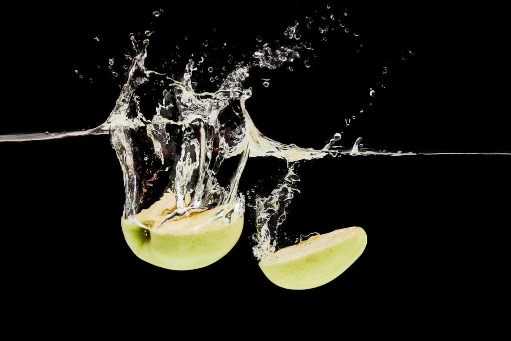 leikattu kypsä omena putoaa syvälle veteen roiskeita eristetty musta
 - Valokuva, kuva