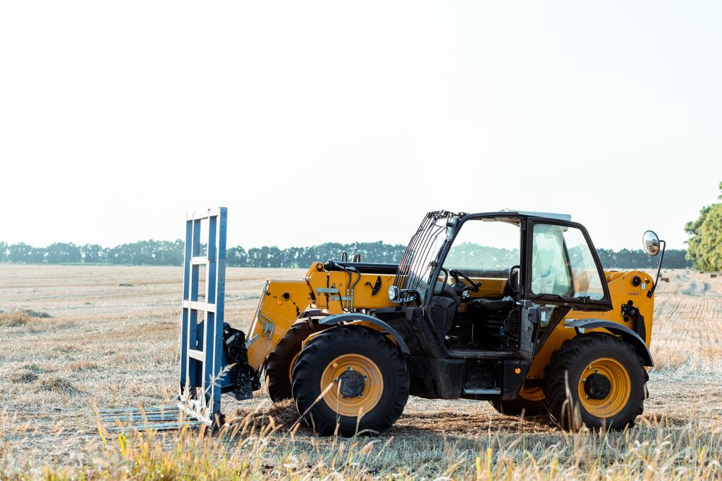 moderni traktori vehnäpellolla maassa
  - Valokuva, kuva