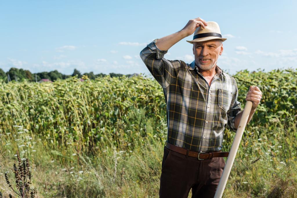 boldog önálló vállalkozó férfit gazdaság rack közelében zöld mező  - Fotó, kép