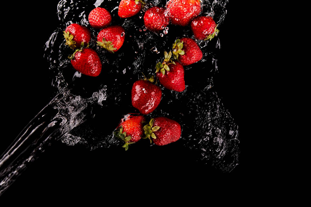 Widok z góry na czerwone truskawki z wodą odpryskową na czarno - Zdjęcie, obraz