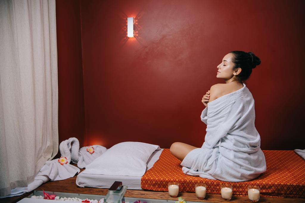 attraktive Frau im Bademantel auf Massagematte im Wellness-Salon - Foto, Bild
