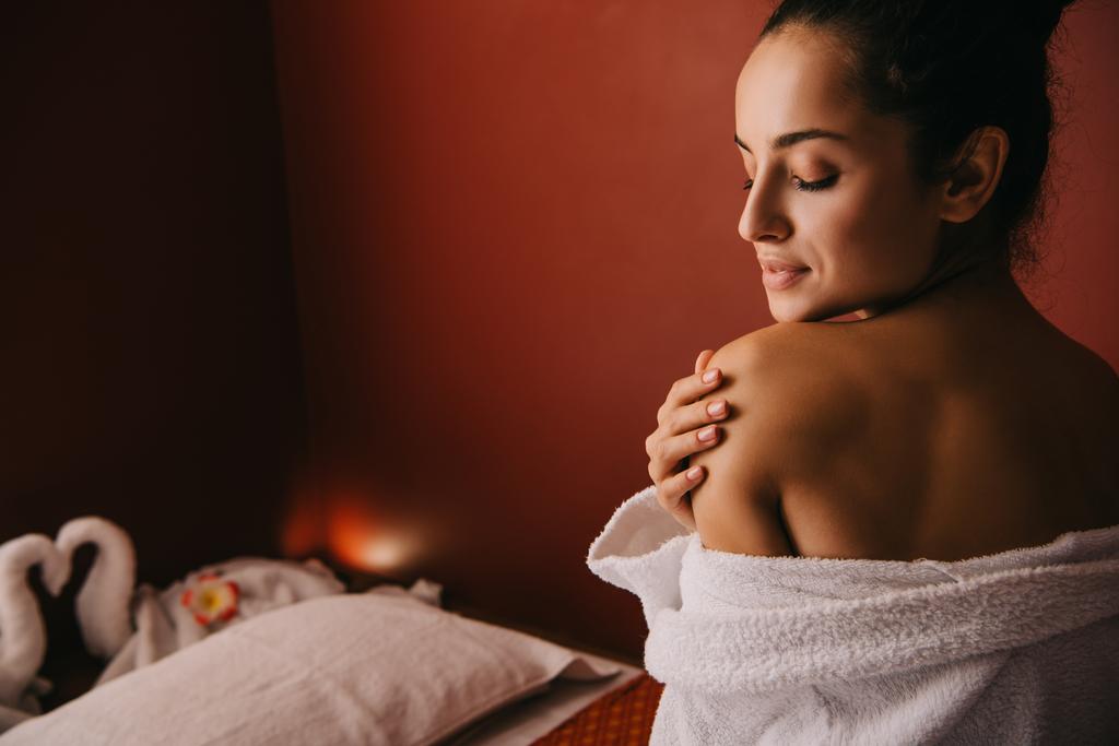 attractive woman with closed eyes in bathrobe in spa salon - Photo, Image