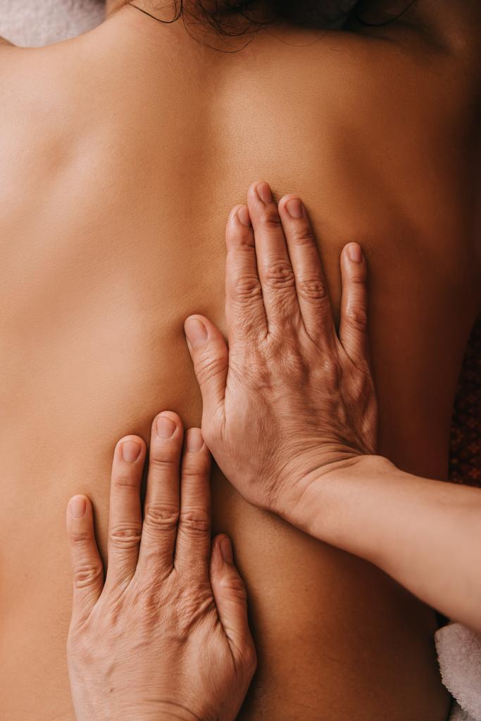 bijgesneden weergave van masseur doet terug massage naar vrouw in Spa  - Foto, afbeelding