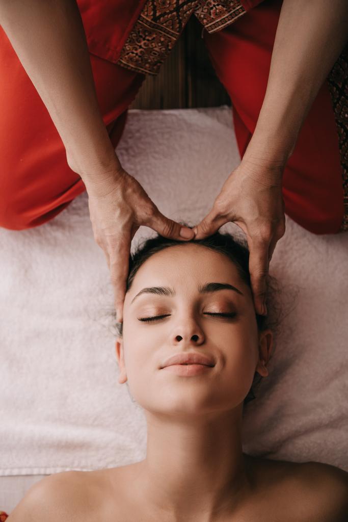vista recortada de masajista haciendo masaje facial a mujer en salón de spa
  - Foto, Imagen