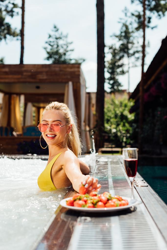 fille sexy en maillot de bain avec du vin rouge et des fraises dans la piscine
 - Photo, image