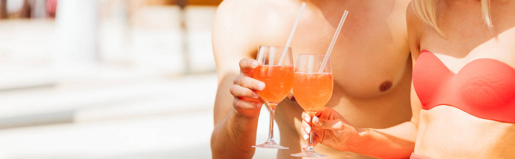 panoramische shot van sexy paar met cocktails in Resort - Foto, afbeelding