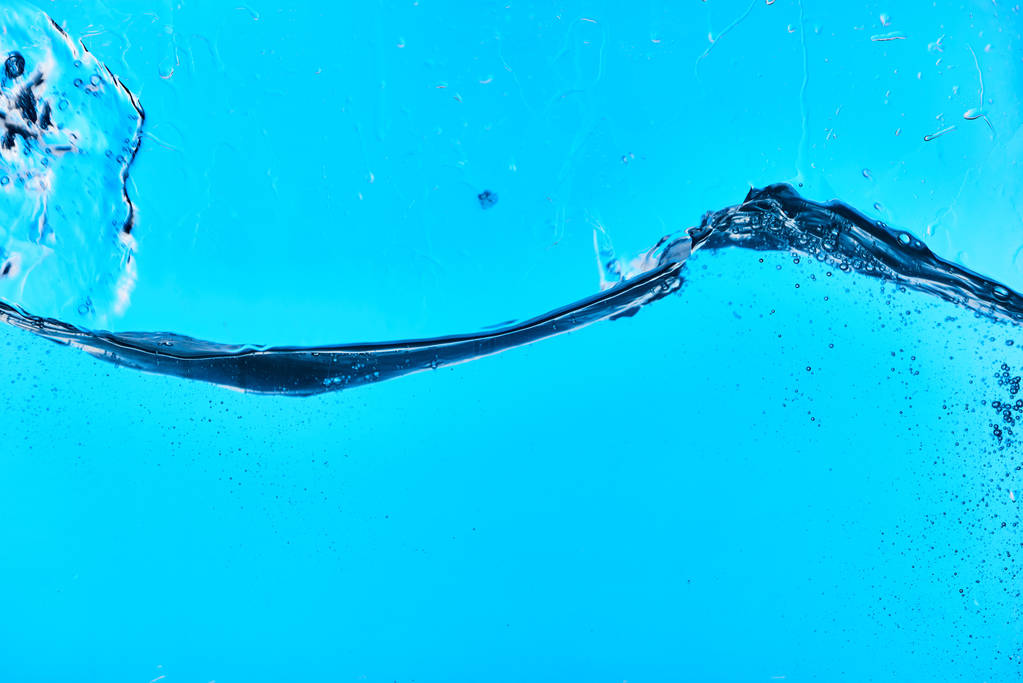 wavy clear splashing water on blue background with drops - Photo, Image