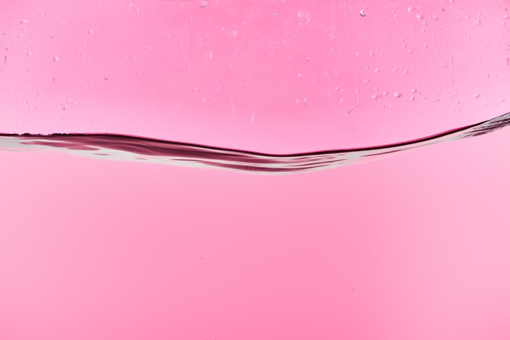 滴とピンクの背景に波状の淡水 - 写真・画像