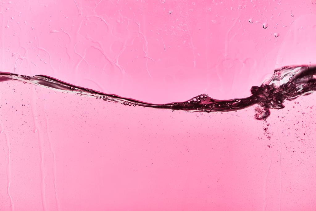καθαρό νερό σε ροζ φόντο με σταγόνες - Φωτογραφία, εικόνα