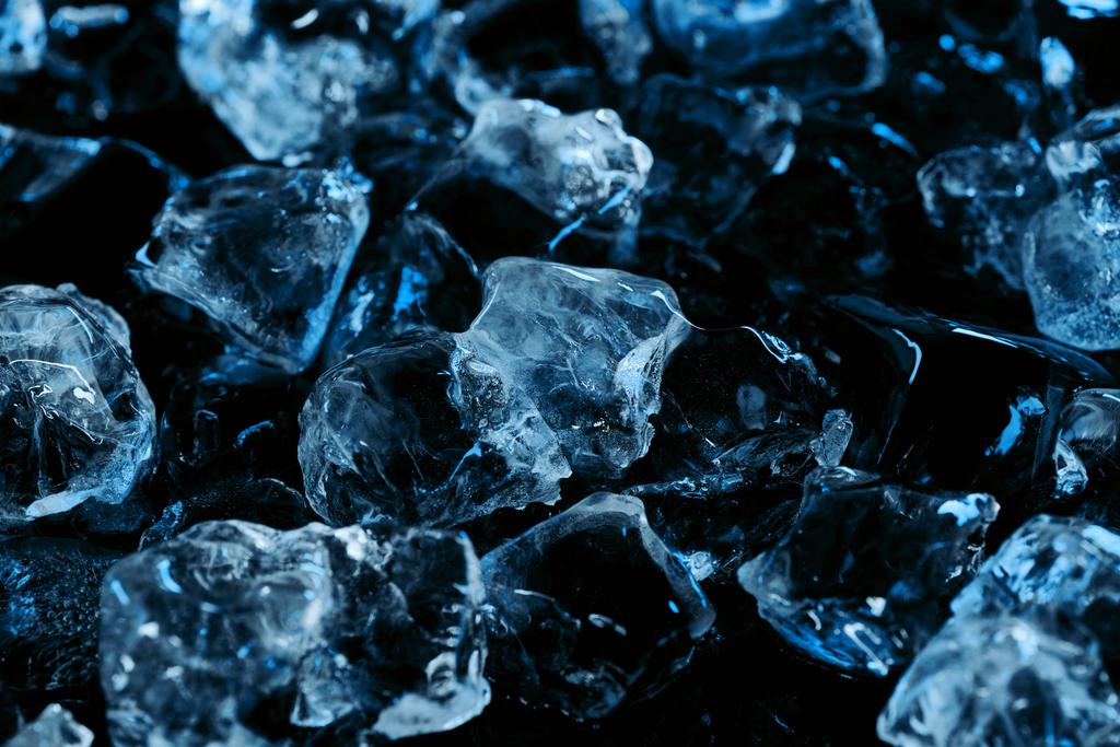 κατεψυγμένα καθαρά παγάκια με μπλε φωτισμό που απομονώνεται σε μαύρο - Φωτογραφία, εικόνα
