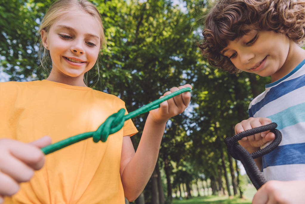 selektywne skupienie się szczęśliwych dzieci trzymających liny w parku  - Zdjęcie, obraz
