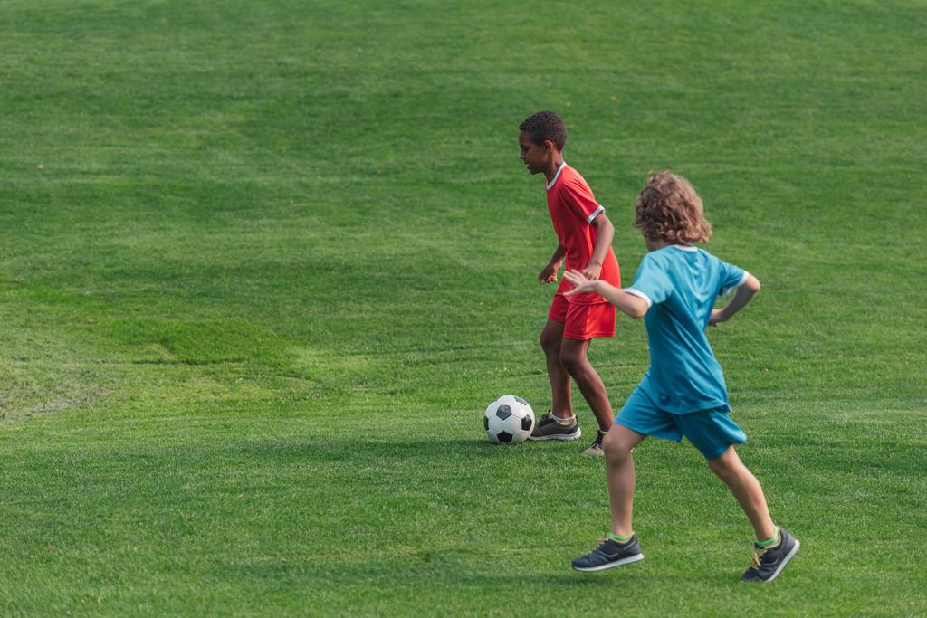 söpö monikulttuurinen lapset pelaa jalkapalloa ruohoa
  - Valokuva, kuva