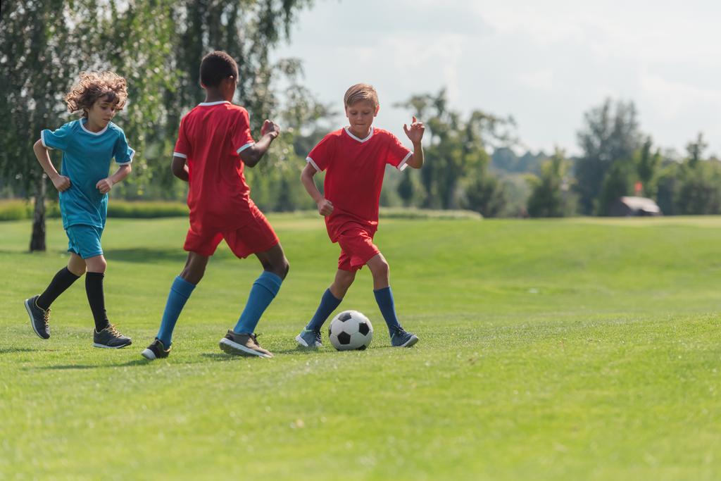 selective focus of multicultural children playing football  - Photo, Image
