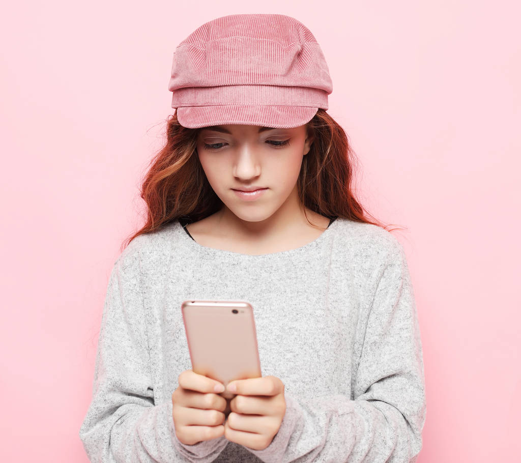Mensen, technologie en internet concept - kleine meisje kind met smartphone over roze achtergrond - Foto, afbeelding