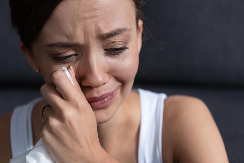 chateado jovem mulher chorando e enxugando lágrimas em casa
 - Foto, Imagem