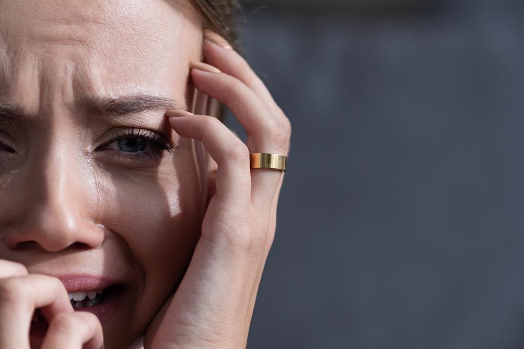 vista parcial de mujer joven molesta con el llanto del anillo y mirando a la cámara
 - Foto, Imagen