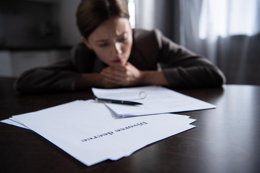 boşanma belgeleri ile masada üzgün kadının seçici odak - Fotoğraf, Görsel