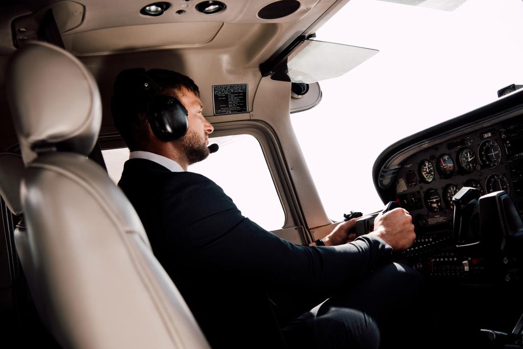 piloto en ropa formal sentado en avión y sosteniendo
  - Foto, Imagen