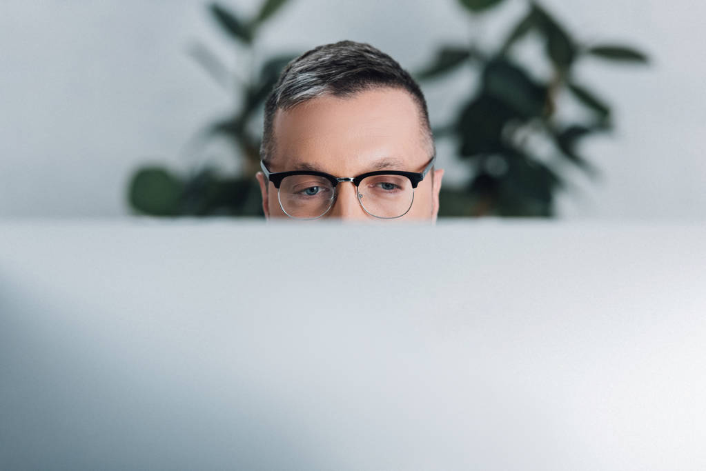 Обрезанный вид человека в очках, смотрящего в сторону офиса
  - Фото, изображение