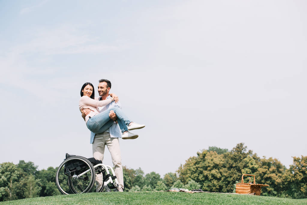 cheerful young man holding on hands happy disabled girlfriend - Photo, Image