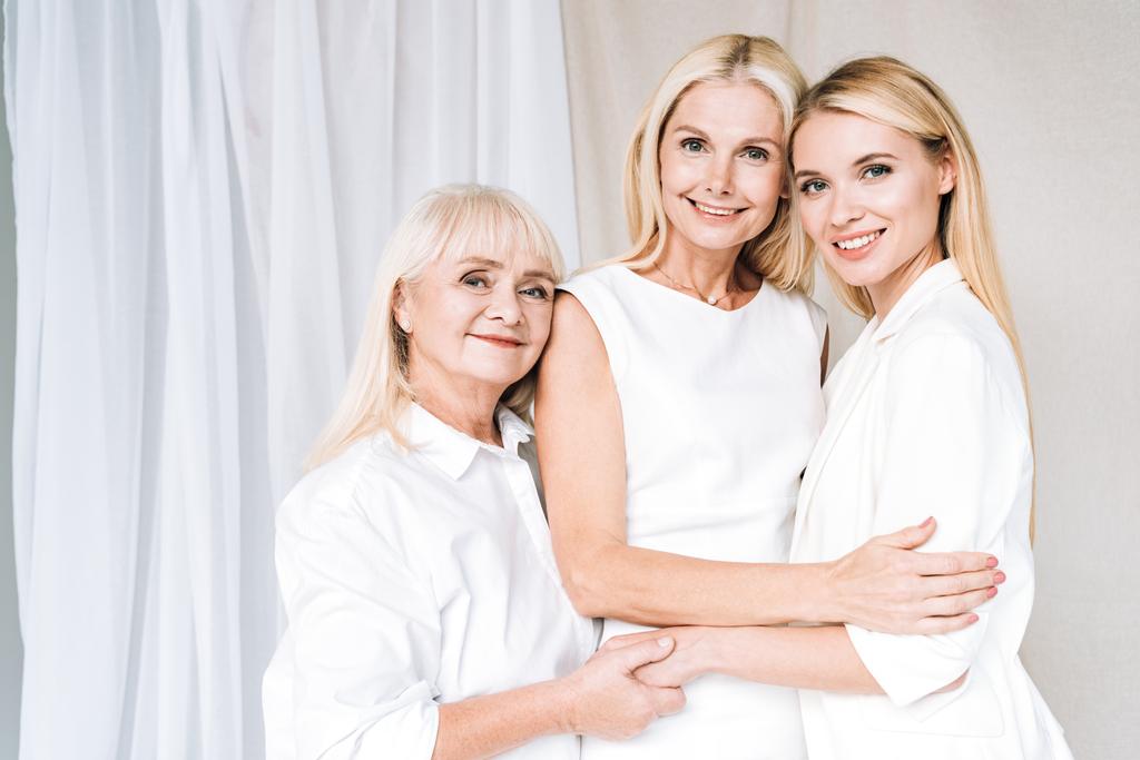 elegante drie generatie blonde gelukkige vrouwen in totaal witte outfits - Foto, afbeelding