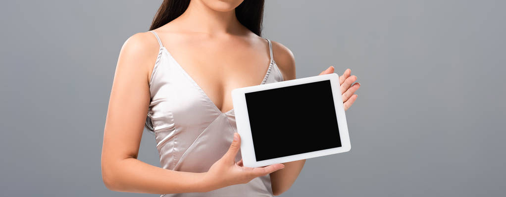 rajattu näkymä seksikäs nainen satiini mekko tilalla digitaalinen tabletti tyhjä näyttö eristetty harmaa
 - Valokuva, kuva