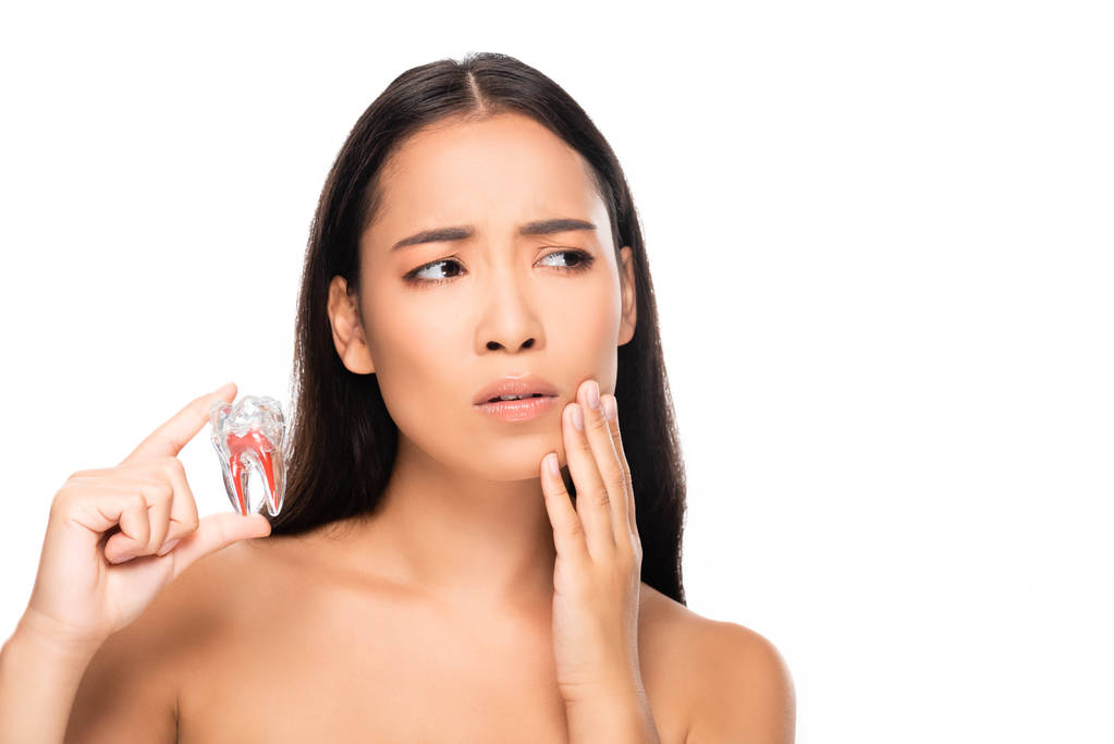 traurige nackte Frau mit Zahnschmerzen hält Zahn Modell isoliert auf weiß - Foto, Bild