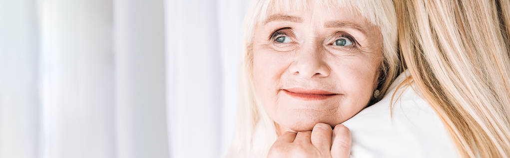 panoraama laukaus blondi hymyilevä isoäiti varovasti syleilee tyttärentytär
 - Valokuva, kuva