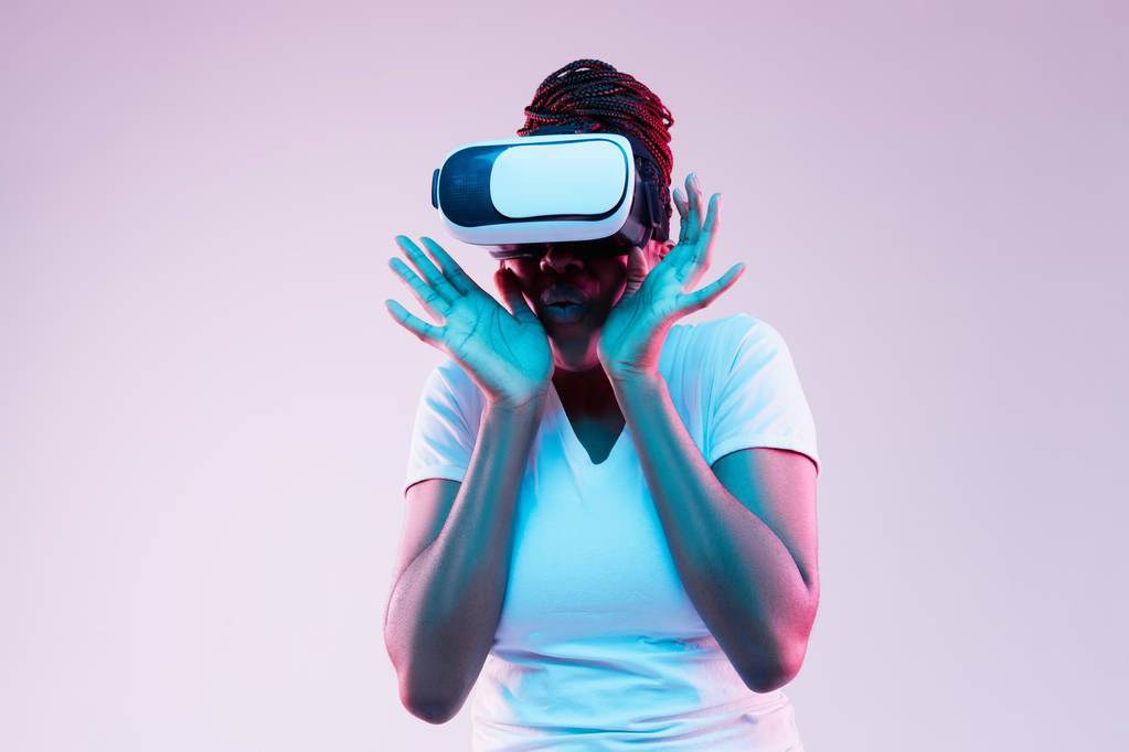 Молодые африканско-американские женщины используют VR-очки в неоновом свете
 - Фото, изображение