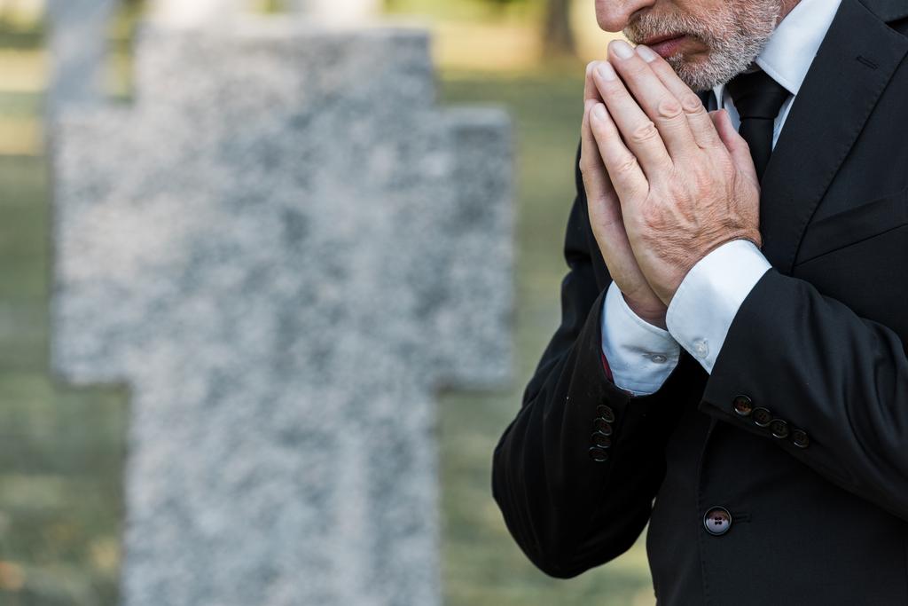 обрізаний вид на старшого чоловіка, що стоїть з молитовними руками
  - Фото, зображення