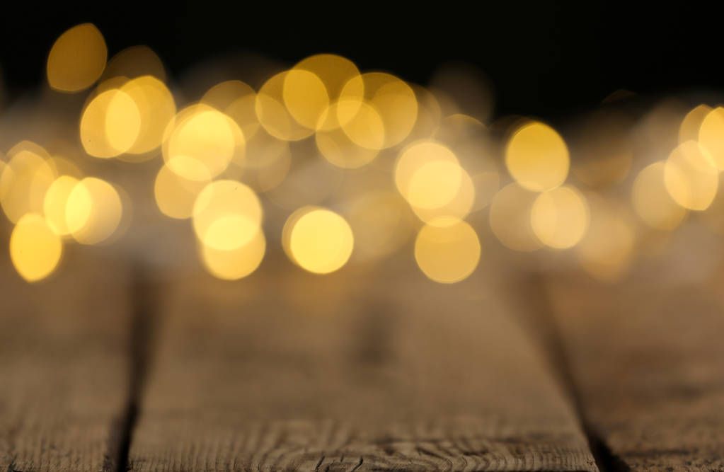 Luzes de Natal amarelas na mesa de madeira, vista turva
 - Foto, Imagem